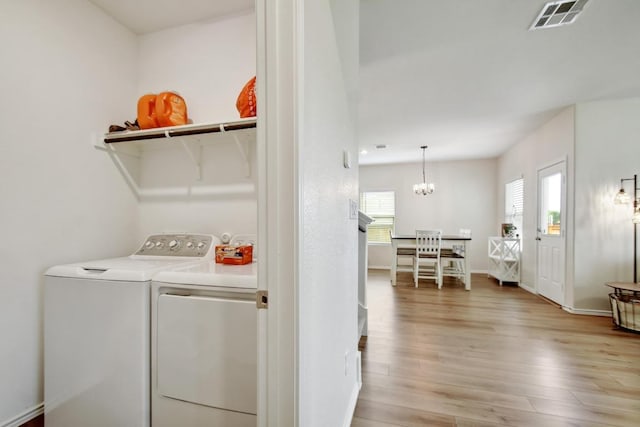 118 Esparza Dr, Bastrop, TX 78602 - laundry area featuring independent washer and dryer, light wood-type flooring, and a chandelier