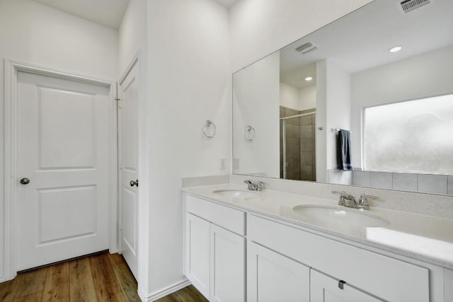 118 Esparza Dr, Bastrop, TX 78602 - full bath with double vanity, tiled shower, wood finished floors, and recessed lighting