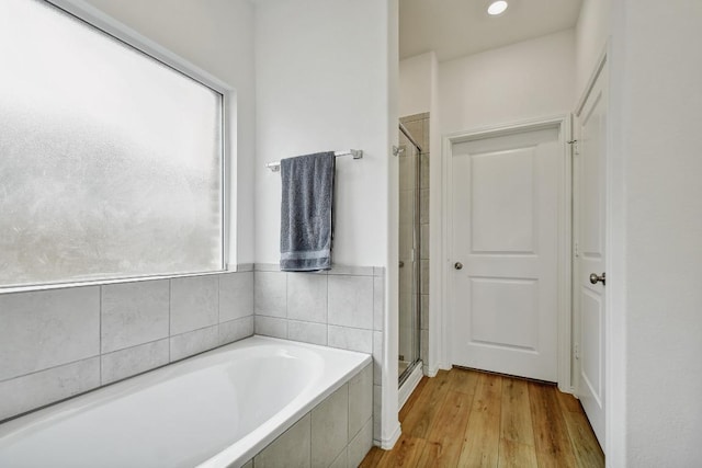 118 Esparza Dr, Bastrop, TX 78602 - full bathroom featuring healthy amount of natural light, a bath, a shower stall, and wood finished floors