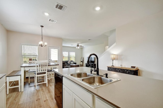 118 Esparza Dr, Bastrop, TX 78602 - kitchen featuring black dishwasher, light wood finished floors, white cabinets, decorative light fixtures, and recessed lighting