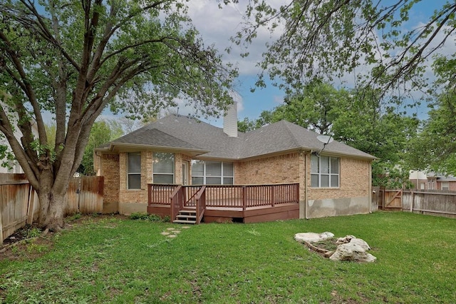 back of house featuring a fenced backyard, brick siding, a yard, and a deck