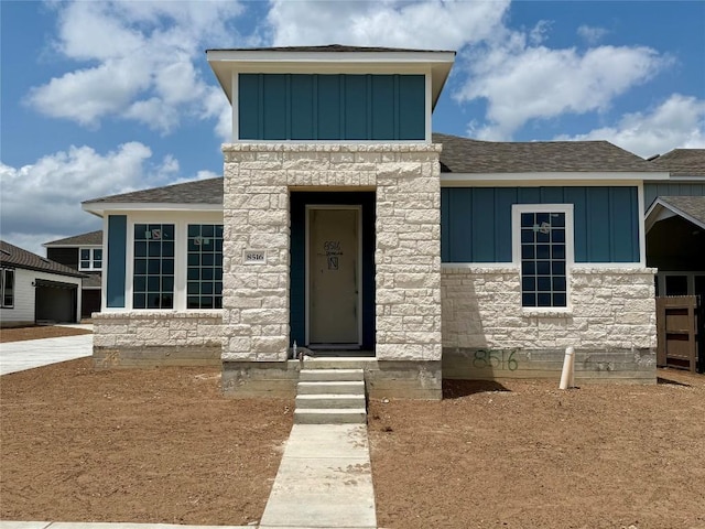 8516 Dongan Dr, Austin, TX 78744 - view of front of home featuring board and batten siding, stone siding, and roof with shingles