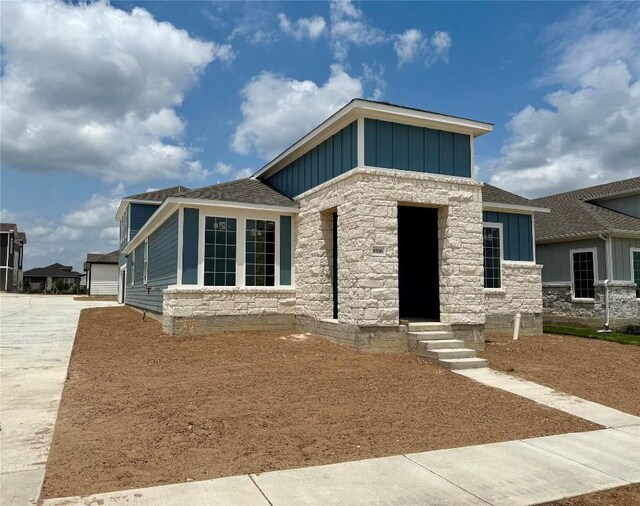 8516 Dongan Dr, Austin, TX 78744 - view of front of house with board and batten siding, concrete driveway, and stone siding