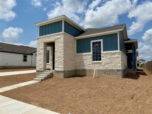 8516 Dongan Dr, Austin, TX 78744 - modern home with a shingled roof, board and batten siding, and stone siding
