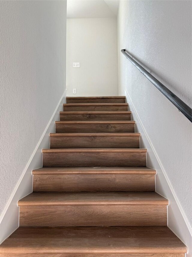 8516 Dongan Dr, Austin, TX 78744 - staircase with a textured wall and wood finished floors