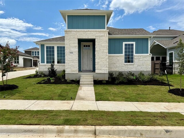 8516 Dongan Dr, Austin, TX 78744 - view of front facade with board and batten siding, stone siding, and roof with shingles