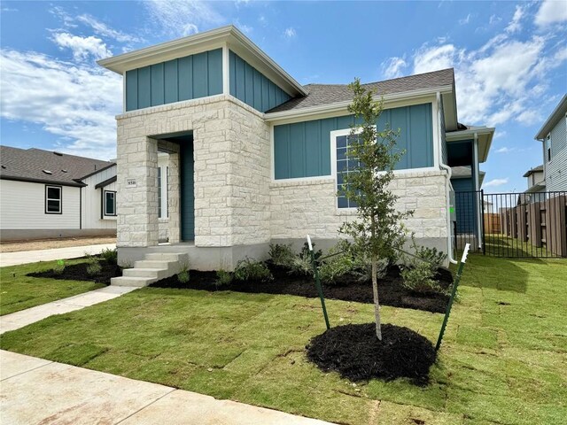 8516 Dongan Dr, Austin, TX 78744 - view of front of home featuring board and batten siding, stone siding, and a shingled roof