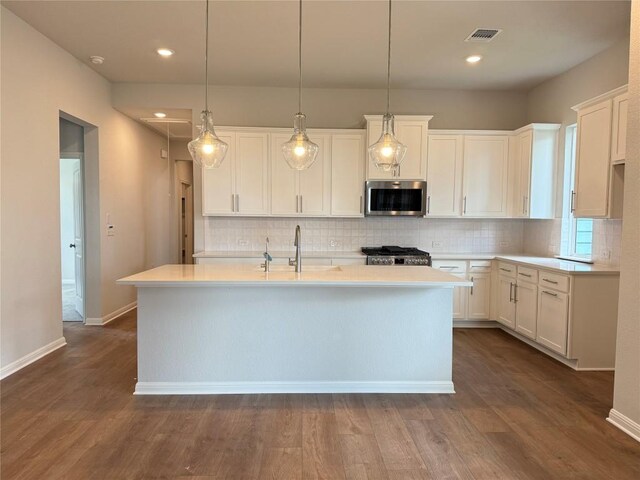 8516 Dongan Dr, Austin, TX 78744 - kitchen with stainless steel microwave, decorative backsplash, white cabinets, light countertops, and recessed lighting
