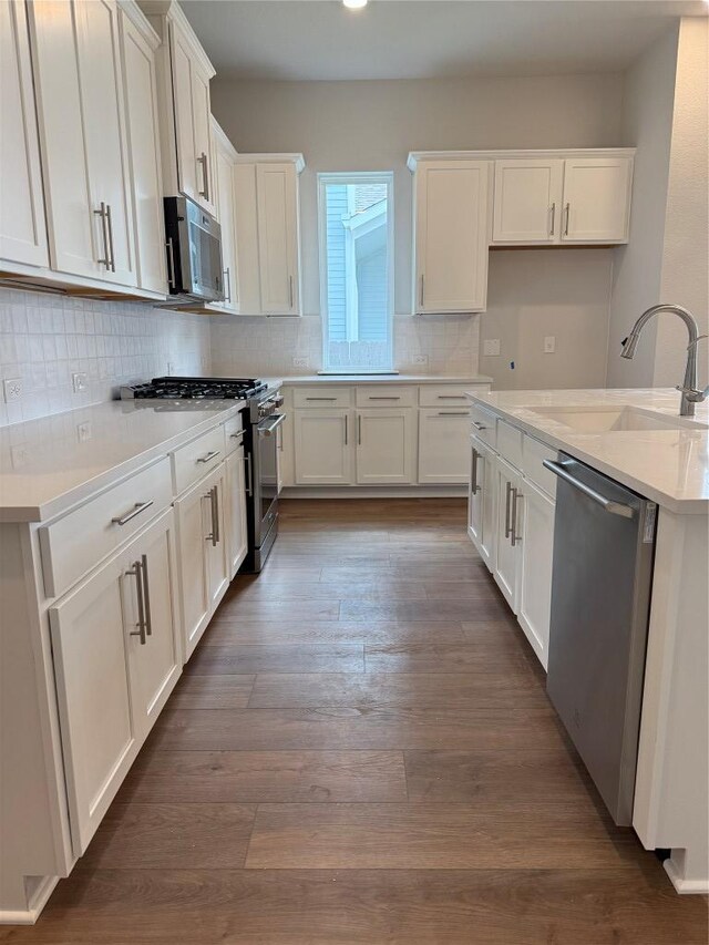 8516 Dongan Dr, Austin, TX 78744 - kitchen featuring appliances with stainless steel finishes, white cabinets, backsplash, dark wood-style floors, and recessed lighting