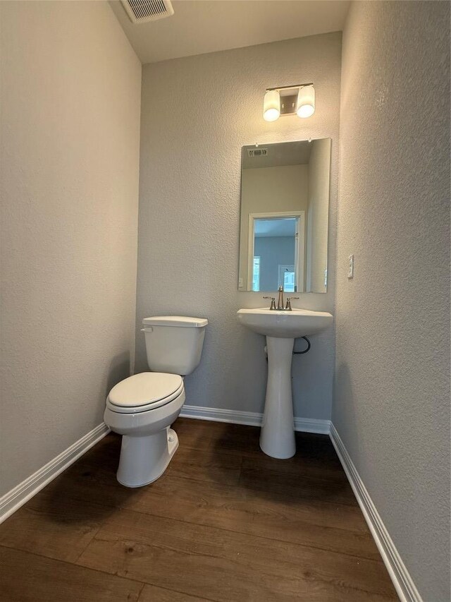 8516 Dongan Dr, Austin, TX 78744 - half bath featuring toilet and wood finished floors