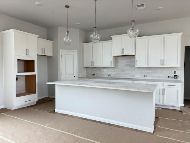 8600 Dongan Dr, Austin, TX 78744 - kitchen with a center island, decorative backsplash, white cabinets, and visible vents