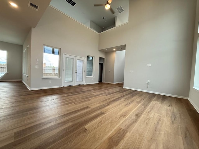 8600 Dongan Dr, Austin, TX 78744 - unfurnished living room featuring a ceiling fan, wood finished floors, and a towering ceiling