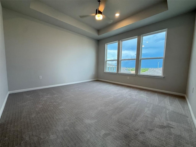 8600 Dongan Dr, Austin, TX 78744 - unfurnished room with a tray ceiling, ceiling fan, dark carpet, and recessed lighting