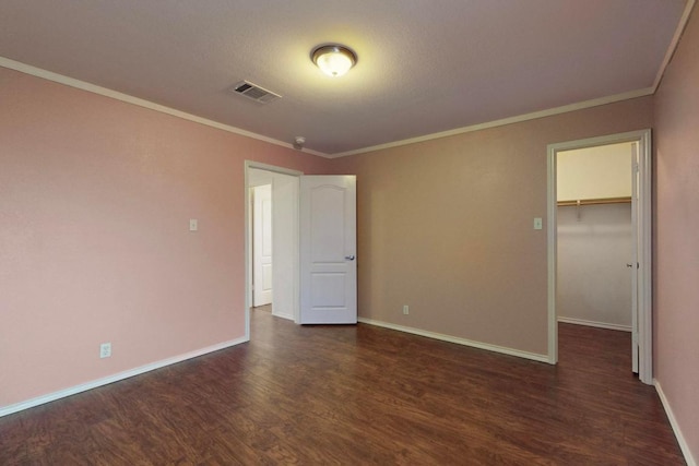 1711 Lloydminister Way, Cedar Park, TX 78613 - unfurnished bedroom with dark wood-type flooring, baseboards, a walk in closet, crown molding, and a closet