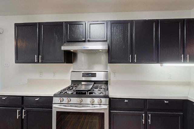 1711 Lloydminister Way, Cedar Park, TX 78613 - kitchen featuring stainless steel gas stove, under cabinet range hood, light countertops, and dark cabinets