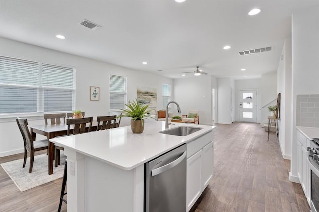13609 Baileyfield Dr, Pflugerville, TX 78660 - kitchen featuring stainless steel appliances, a sink, ceiling fan, light wood-style flooring, and a center island with sink