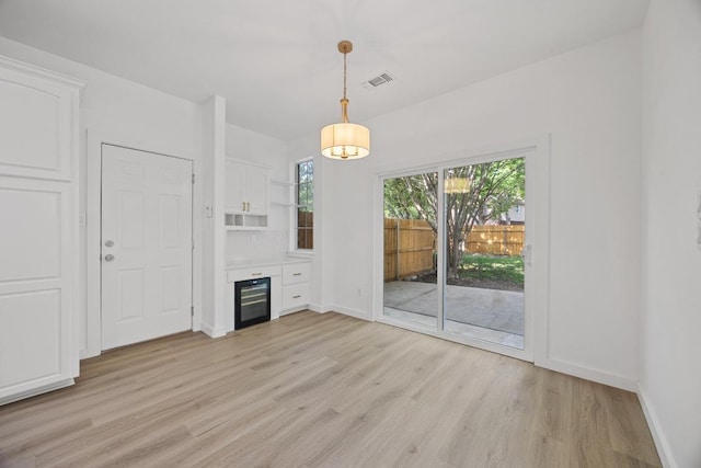 3505 Galena Hills Loop, Round Rock, TX 78681 - unfurnished dining area with wine cooler, light wood-style floors, and a fireplace