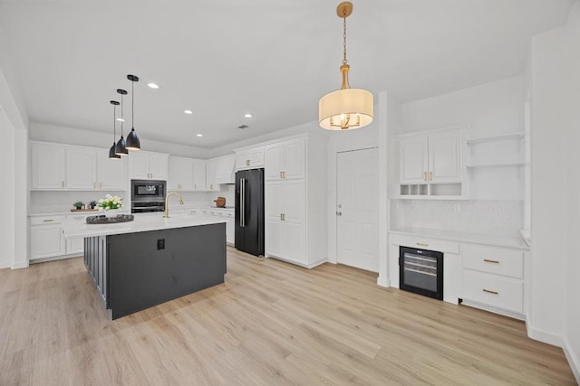 3505 Galena Hills Loop, Round Rock, TX 78681 - kitchen featuring black fridge, built in microwave, wine cooler, oven, and white cabinetry