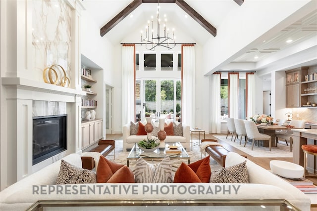 living room featuring a notable chandelier, beam ceiling, recessed lighting, a towering ceiling, and a premium fireplace