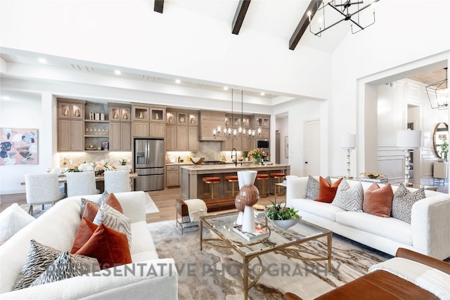 living room with light wood-type flooring, an inviting chandelier, beamed ceiling, and recessed lighting
