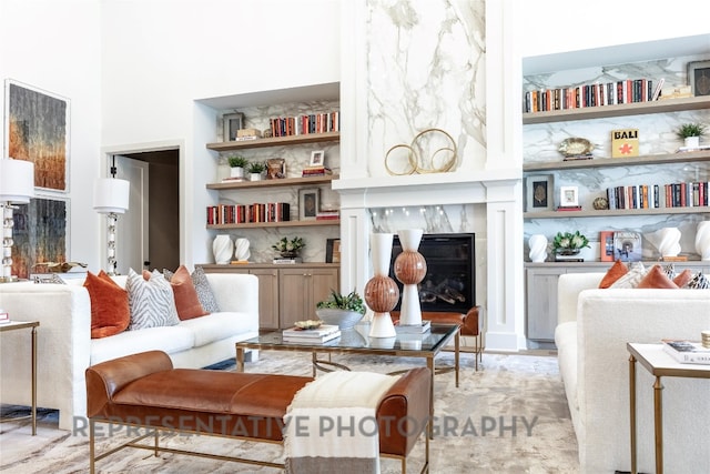 living area with a towering ceiling and a fireplace