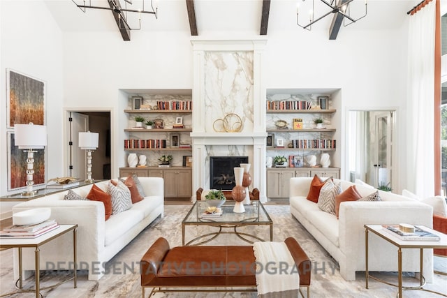 living room with a high ceiling, a fireplace, and a notable chandelier