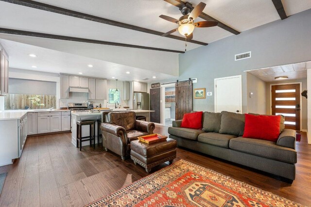 5310 Fort Clark Dr, Austin, TX 78745 - living room featuring a barn door, beamed ceiling, ceiling fan, dark wood-type flooring, and high vaulted ceiling