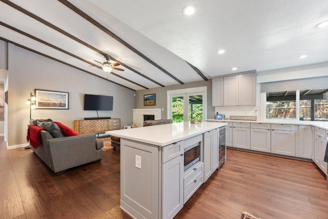 5310 Fort Clark Dr, Austin, TX 78745 - kitchen featuring stainless steel microwave, a fireplace, dark wood-type flooring, light countertops, and recessed lighting