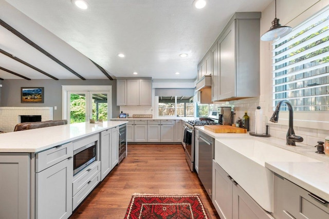5310 Fort Clark Dr, Austin, TX 78745 - kitchen with appliances with stainless steel finishes, gray cabinets, a sink, backsplash, and light countertops