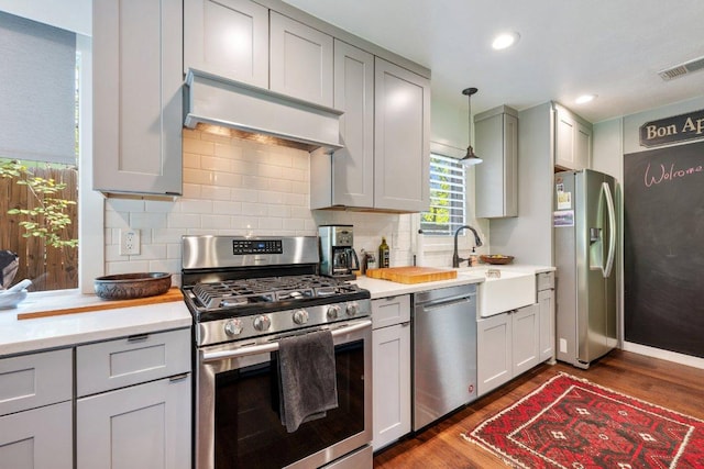 5310 Fort Clark Dr, Austin, TX 78745 - kitchen featuring stainless steel appliances, premium range hood, dark wood-style flooring, light countertops, and backsplash