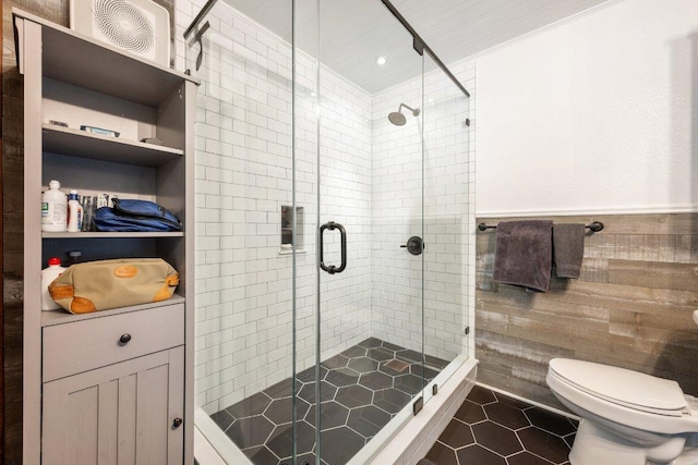 5310 Fort Clark Dr, Austin, TX 78745 - bathroom featuring a stall shower, toilet, tile patterned floors, and wainscoting