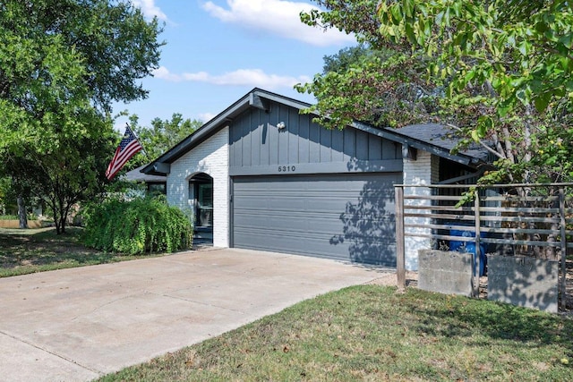 5310 Fort Clark Dr, Austin, TX 78745 - view of front of house with an attached garage, brick siding, and driveway