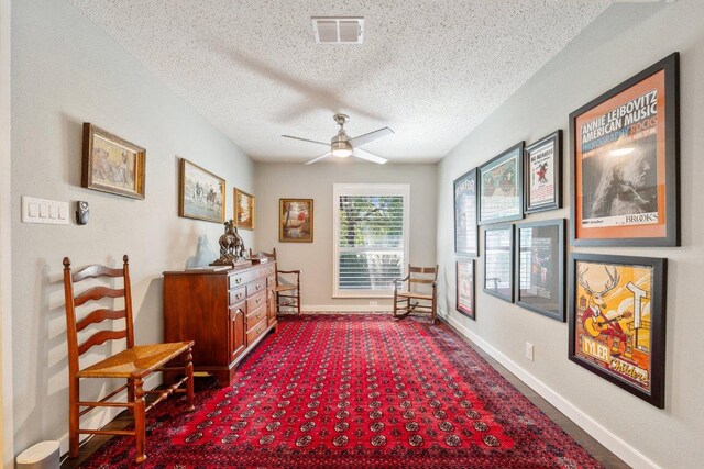 5310 Fort Clark Dr, Austin, TX 78745 - living area with a textured ceiling, baseboards, ceiling fan, and dark colored carpet