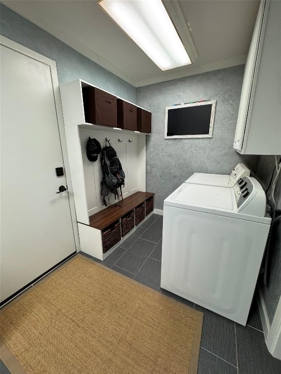 5310 Fort Clark Dr, Austin, TX 78745 - washroom featuring washer / dryer, cabinet space, and dark tile patterned flooring
