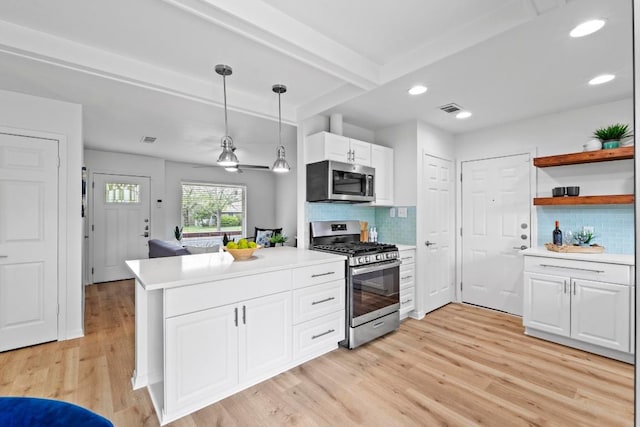 7003 Priscilla Dr, Austin, TX 78752 - kitchen featuring stainless steel appliances, light countertops, light wood finished floors, white cabinetry, and recessed lighting