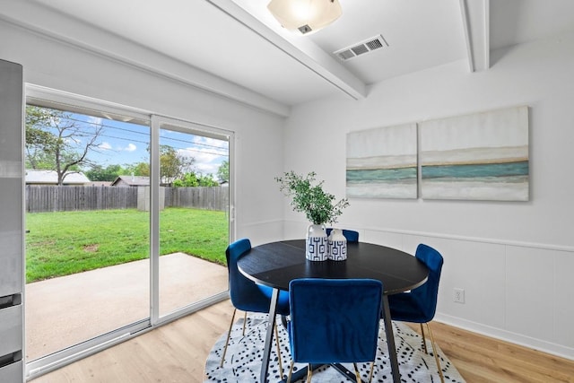 7003 Priscilla Dr, Austin, TX 78752 - dining area featuring beam ceiling, healthy amount of natural light, wood finished floors, and wainscoting