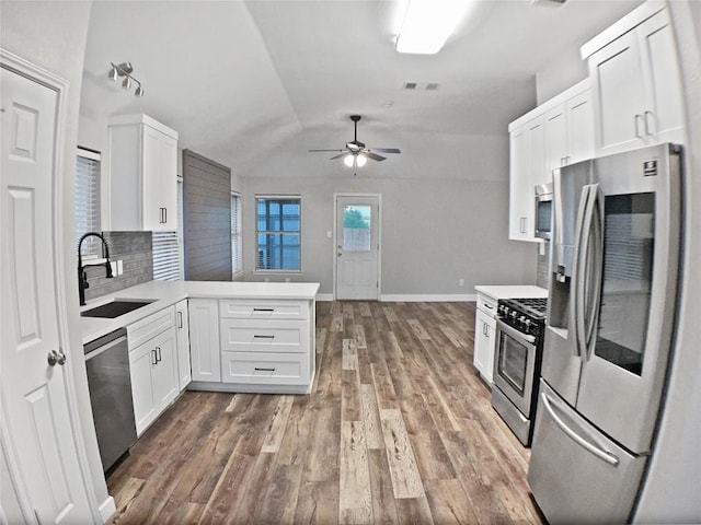 1608 Mallard Ln, Taylor, TX 76574 - kitchen featuring stainless steel appliances, a peninsula, a ceiling fan, lofted ceiling, and white cabinets