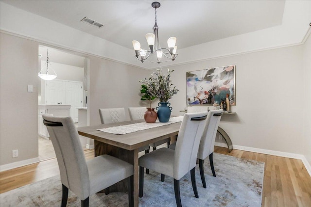 7306 Fireoak Dr, Austin, TX 78759 - dining room with a chandelier, light wood-type flooring, and a tray ceiling
