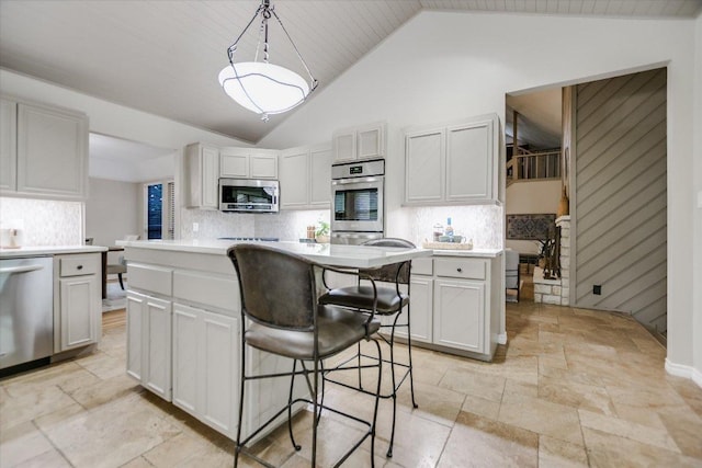 7306 Fireoak Dr, Austin, TX 78759 - kitchen with appliances with stainless steel finishes, stone tile flooring, vaulted ceiling, and light countertops