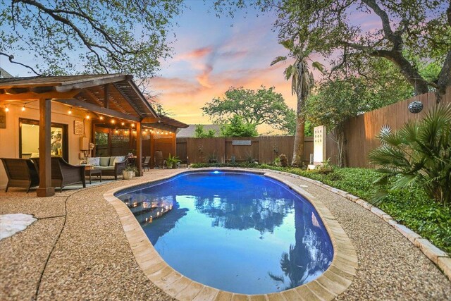 7306 Fireoak Dr, Austin, TX 78759 - pool at dusk with an outdoor living space, a fenced backyard, and a patio