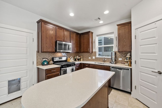 1900 Teagle Dr, Austin, TX 78741 - kitchen with stainless steel appliances, a sink, backsplash, a kitchen island, and light countertops
