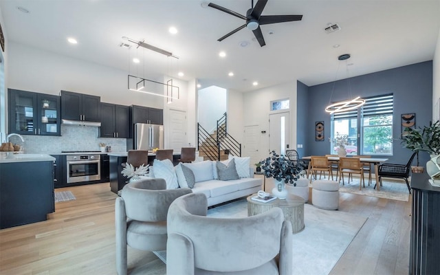 6221 Florencia Ln, Austin, TX 78724 - living room with stairs, light wood-type flooring, a ceiling fan, and recessed lighting