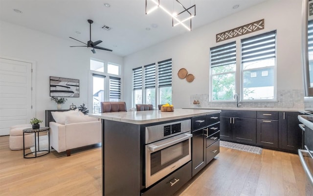 6221 Florencia Ln, Austin, TX 78724 - kitchen with light wood-style flooring, healthy amount of natural light, open floor plan, and a center island