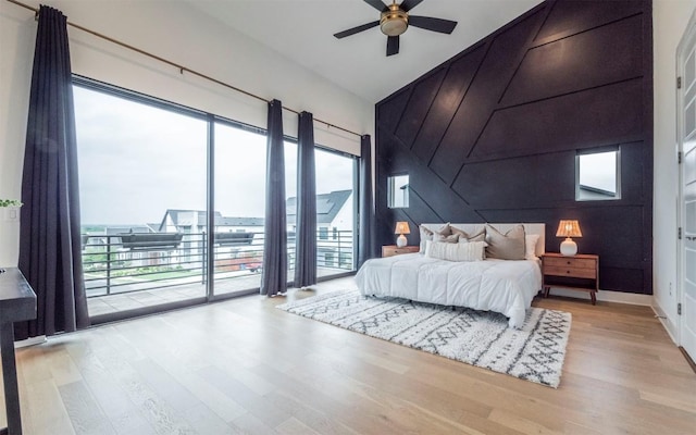 6221 Florencia Ln, Austin, TX 78724 - bedroom with wood finished floors, access to outside, an accent wall, high vaulted ceiling, and ceiling fan