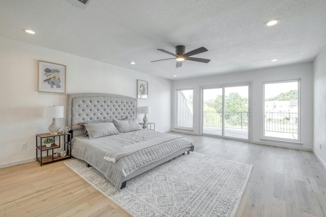 313 Lucy Ln, Horseshoe Bay, TX 78657 - bedroom featuring access to exterior, light wood-style floors, a textured ceiling, recessed lighting, and baseboards