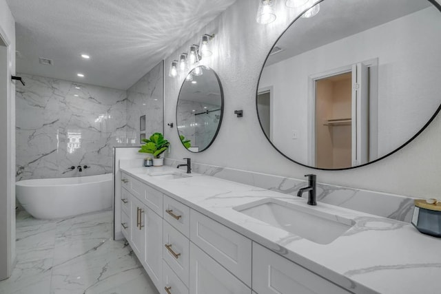 313 Lucy Ln, Horseshoe Bay, TX 78657 - full bath featuring a soaking tub, double vanity, marble finish flooring, recessed lighting, and a marble finish shower