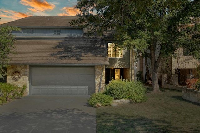 313 Lucy Ln, Horseshoe Bay, TX 78657 - view of front of house with stone siding, concrete driveway, a garage, and a yard