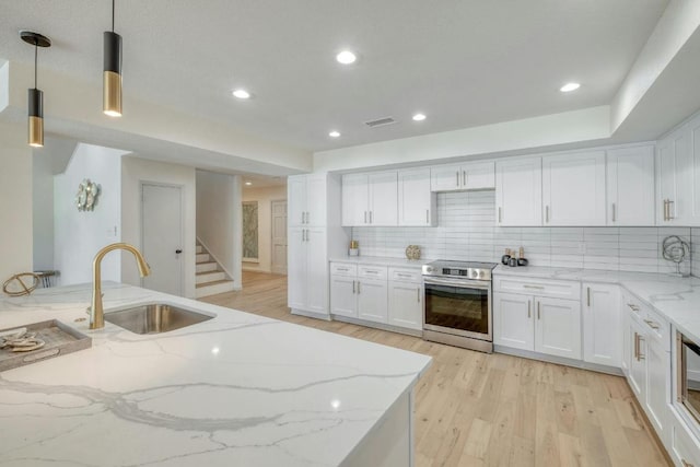 313 Lucy Ln, Horseshoe Bay, TX 78657 - kitchen with electric stove, a sink, light wood-style flooring, white cabinets, and recessed lighting