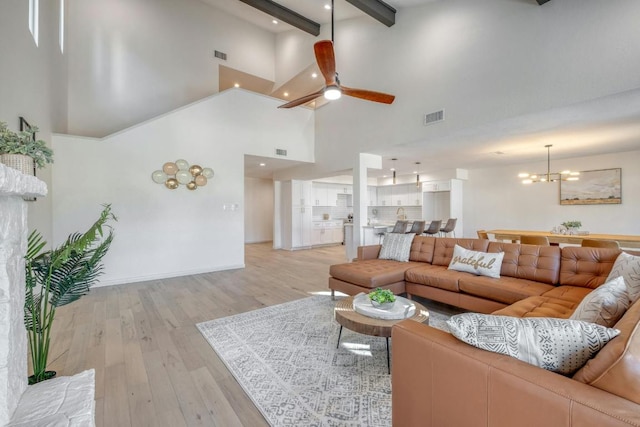 313 Lucy Ln, Horseshoe Bay, TX 78657 - living room featuring high vaulted ceiling, beamed ceiling, light wood-style flooring, ceiling fan, and a chandelier