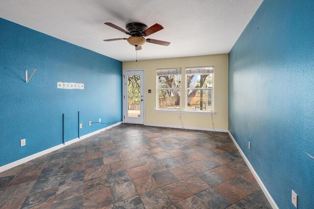 4142 Rockwood Dr, Lago Vista, TX 78645 - spare room featuring a ceiling fan, a textured wall, and stone finish floors